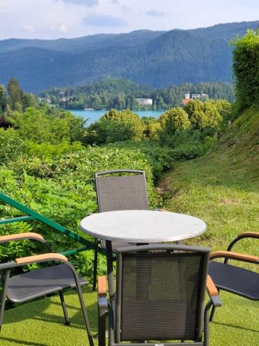 a table and chairs on a balcony with a view of a lake at Murka Holiday Home in Bled