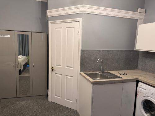 a kitchen with a sink and a white door at Regent Hotel in Eastbourne
