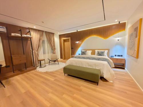 a large bedroom with a bed and a chair at Amazonia Luxury in Abuja