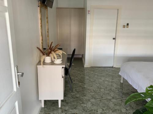 ein Schlafzimmer mit einem Bett und einem Tisch mit einem Stuhl in der Unterkunft Zenaida in Paramaribo