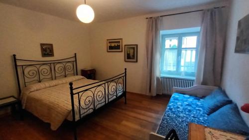 a bedroom with a bed and a couch and a window at Casa SAN FELICE in Mori
