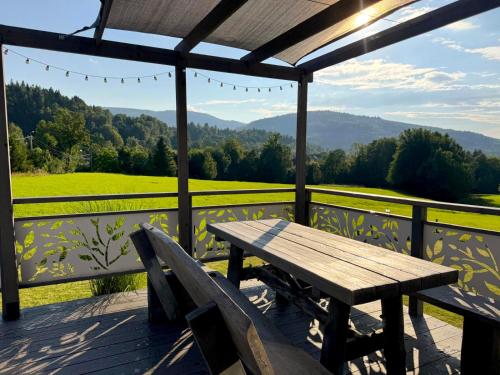 a wooden table and two chairs on a deck with a view at KORBIELOVKA domek z sauną in Korbielów