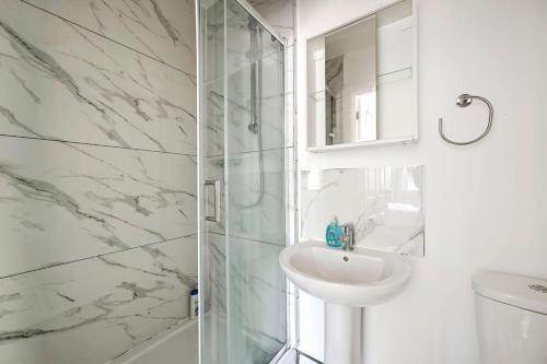a white bathroom with a sink and a shower at Two bedrooms apartment in Wainscot
