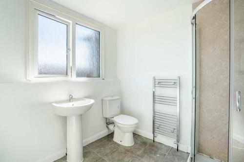 a bathroom with a toilet and a sink and a window at DD Private Double Room with Shared Bathroom in York
