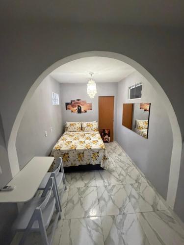 a bedroom with a bed and a table in a room at Escondidinho Bar, hostel e casa de festas in Rio de Janeiro