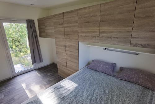 a bedroom with a bed and a large window at Forest house Maestral in Koper