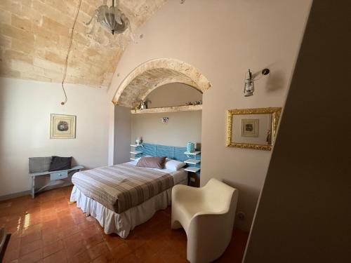 a bedroom with a bed and a chair in a room at Corte dei Venti in Matera