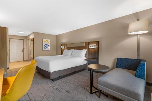 a hotel room with a bed and a chair at Holiday Inn Express Biddeford by IHG in Biddeford