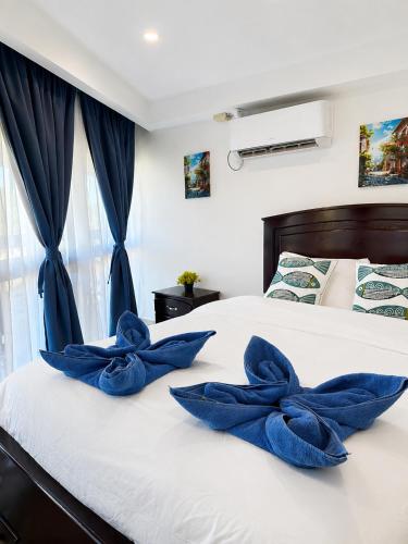 a bedroom with blue pillows on a white bed at Costa Catalina in Santa Catalina