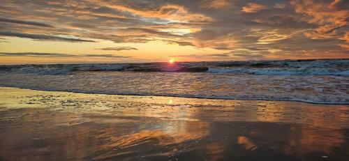 a sunset on a beach with the ocean at Nad Krolewiecka in Sztutowo