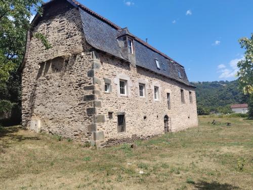an old stone building sitting in a field at Lo Castel de Lasmaries in Saint-Parthem