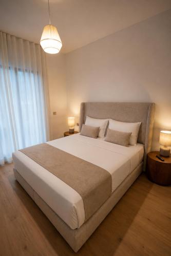 a bedroom with a large white bed with two lamps at Royal Rif Tanger Marina Bay in Tangier