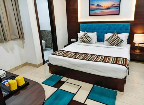 a hotel room with a bed and a desk with a table at Taj Comfort Inn in Agra