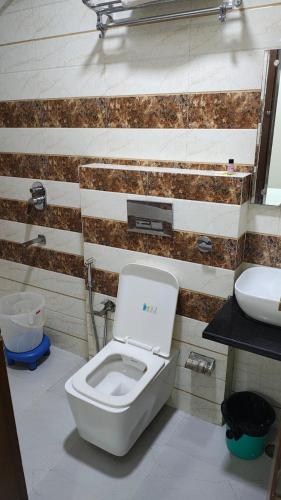 a bathroom with a toilet and a sink at Taj Comfort Inn in Agra