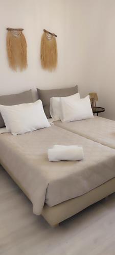 two beds with white pillows on top of them at Maria Studios in Parikia
