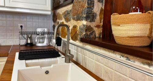 a kitchen sink with a faucet and a basket at Palatino Seafront Residence in Alinda