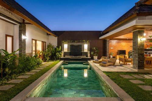a backyard with a swimming pool and a house at Lapiz Lazuli in Seminyak