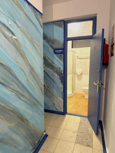 a door to a bathroom with a painting on the wall at Evans Realty - Hostal in Fuengirola