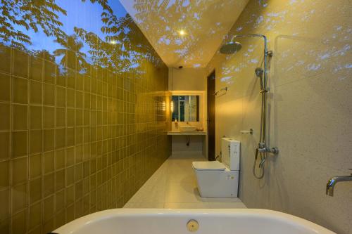 a bathroom with a tub and a shower and a toilet at The Plunge by Duo Escapes in Gonahena
