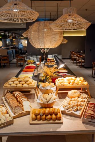 a buffet with many different types of bread and pastries at Ibis Florianopolis in Florianópolis