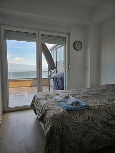 a bedroom with a bed and a sliding glass door at apartman Dalas Star Dojran in Star Dojran