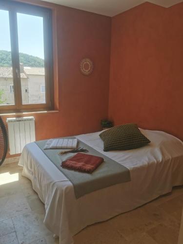 a bedroom with a bed with two pillows and a window at Maison Romana in Riez
