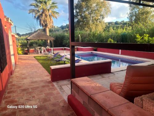 a swimming pool in a house with a patio at La Finca Roja 3 in Coín