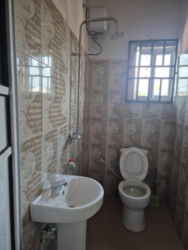 a bathroom with a toilet and a sink at D-vine Apartments & Hotels in Benin City