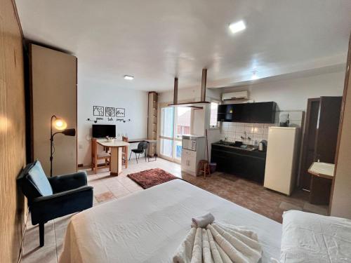a bedroom with a bed and a kitchen with a table at Residencial Alfa in Canoas