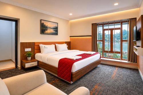 a hotel room with a bed and a large window at Lake Residency Ooty in Ooty