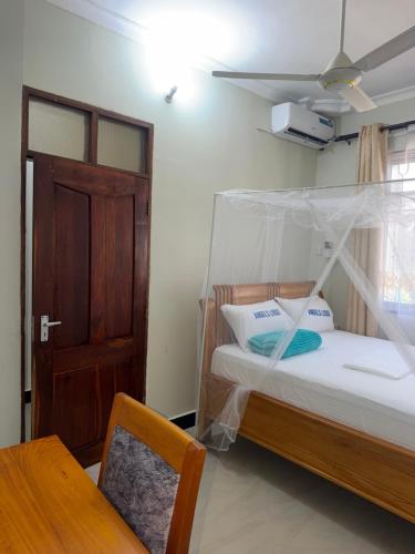 a bedroom with a bed with a canopy at Angels Lodge in Dar es Salaam