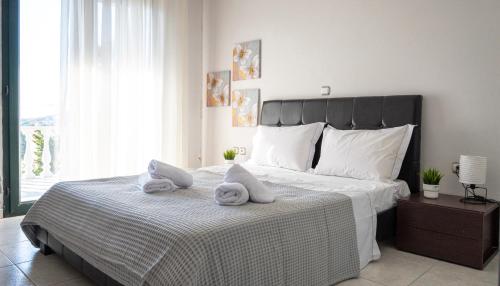 a bedroom with a large bed with towels on it at Villa Twins in Myrina
