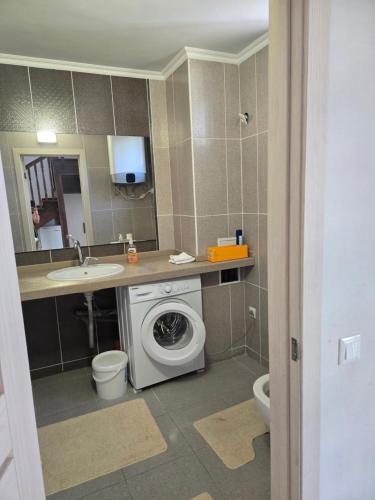 a bathroom with a washing machine and a sink at Baytur-Yilla09 in Bosteri