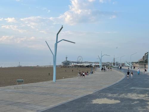 a group of people walking on a sidewalk near the beach at Beach House Rodine - free parking & bikes in Scheveningen
