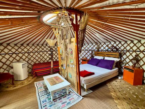 a bedroom with a bed in a yurt at La Yourte climatisée du Jardin Caché in Marmande