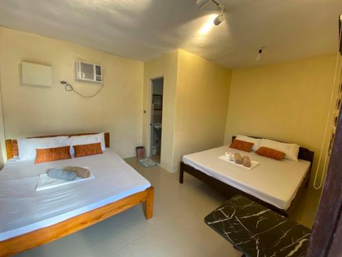two beds in a small room with at V Hostel Galera in Puerto Galera