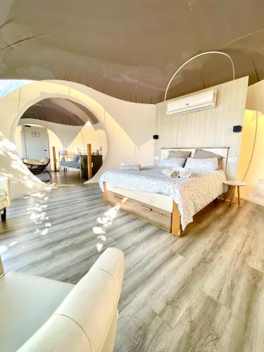 a bedroom with a bed and a couch in a room at Fuente del Lobo Glamping & Bungalows - Adults Only in Pinos Genil