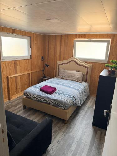 a bedroom with a bed in a room with wooden walls at Le Clos Tranquille in Saint-Privé
