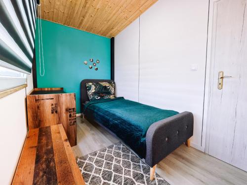 a bedroom with a bed and a blue wall at Dovolenkový dom in Mojš