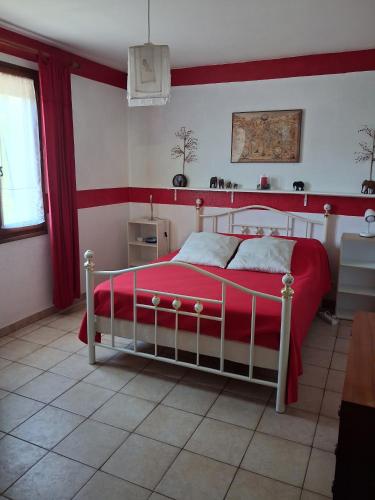 a bedroom with a red and white bed in a room at La borie de la croix in Daglan