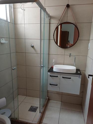 a bathroom with a shower and a sink and a mirror at Apartamento Orquídea in Campos dos Goytacazes