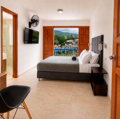 a bedroom with a large bed and a window at Hospedaje Camino Real in Salento