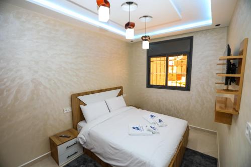 a small bedroom with a bed and a window at Résidence Acharif in Tan-Tan Plage