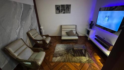 a living room with two chairs and a flat screen tv at Casa comoda con aire y garaje en La Union Valle in Lemos