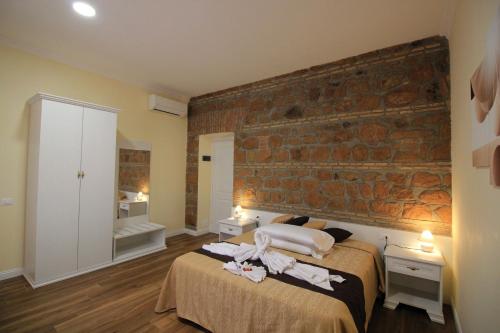 a bedroom with a bed and a brick wall at Freedom Love B&B in Rome