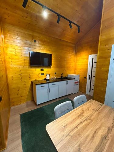 a dining room with a table and a flat screen tv at Royal Park in Arslanbob