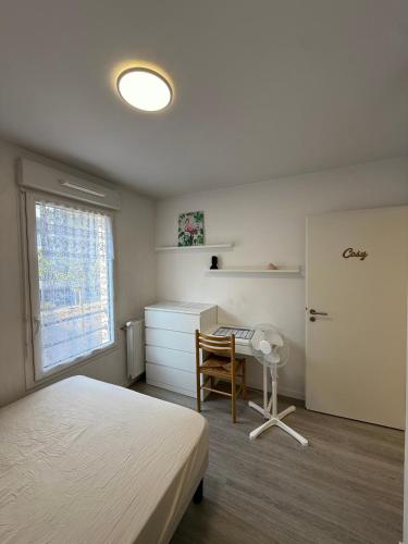 a bedroom with a bed and a desk and a window at Une petite chambre cosy in Dijon