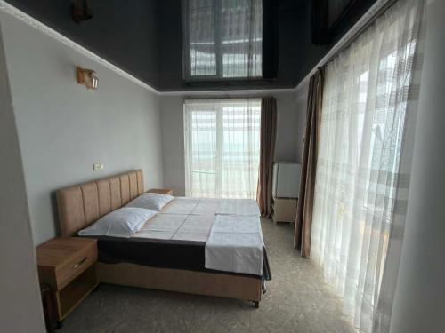 a bedroom with a bed and a large window at Mari House in Buknari
