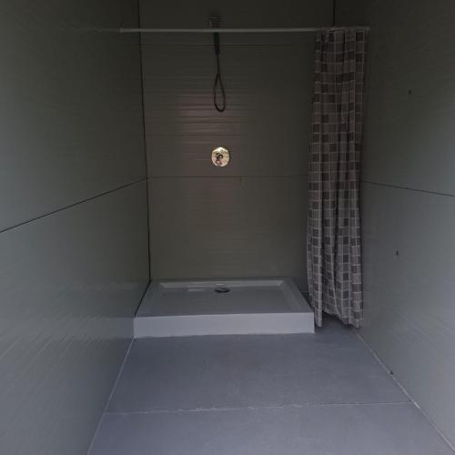 a shower with a tub with a shower curtain at CampingSiriu in Caşoca