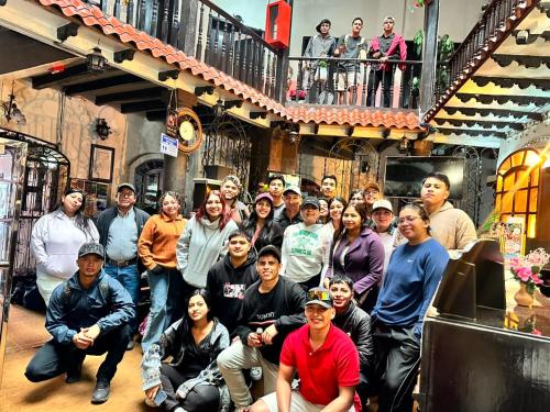 a group of people posing for a picture in a building at Hostal Juana de Arco in Quito